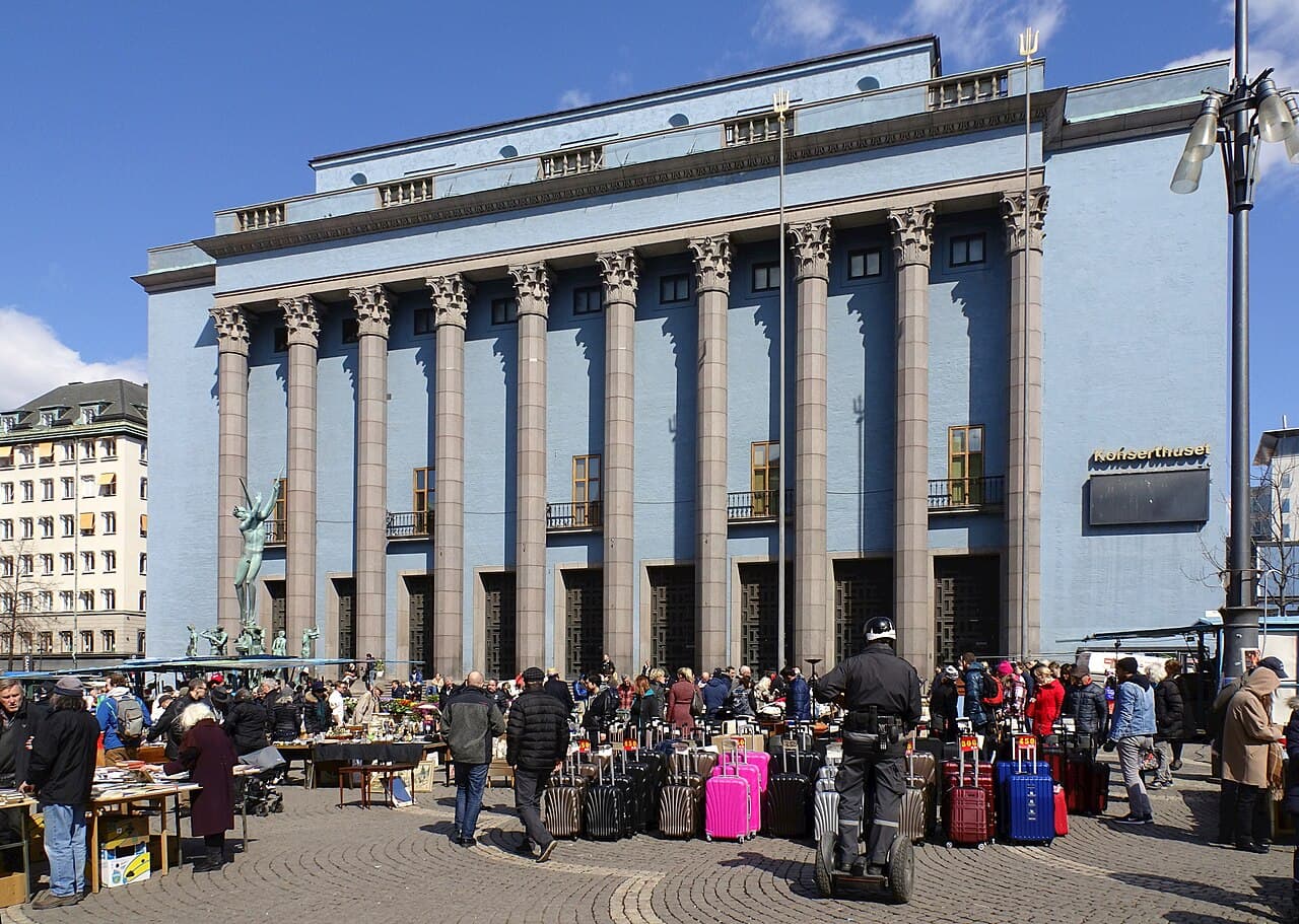 Utomhusloppmarknad på Hötorget i Stockholm med Konserthuset i bakgrunden.