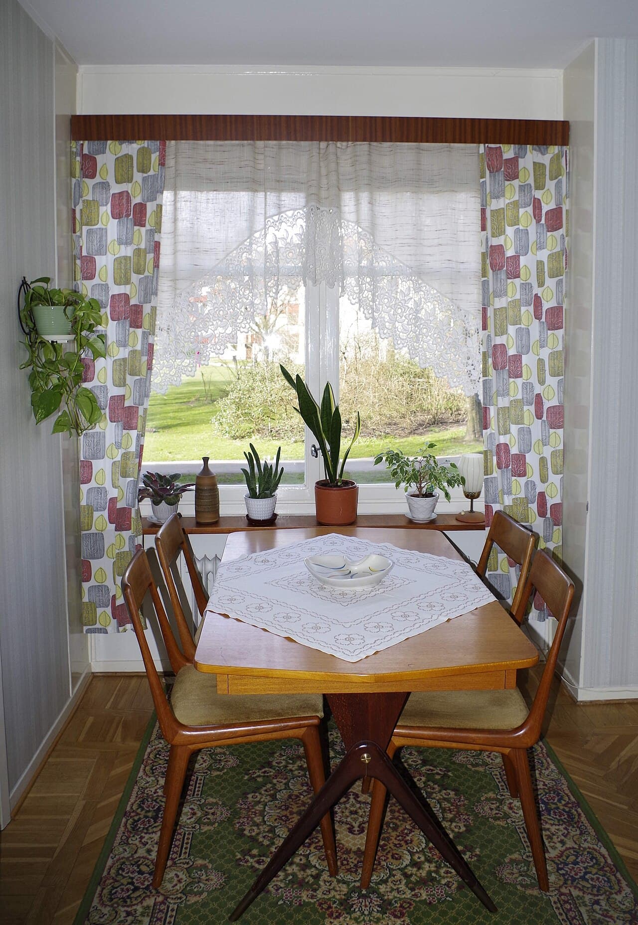 Inrett 1950-talsvardagsrum med fåtöljer, lampa och teakhylla på Kortedala museum.